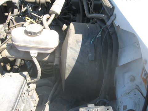 1995 Ford Bronco - Close-up view of engine bay components, including the brake fluid reservoir and vacuum booster.