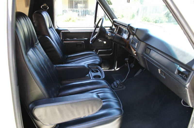 Interior view of a truck with black bucket seats, center console, and dashboard