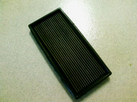 1995 Ford Bronco - This is a black air filter with a ribbed surface, likely for a vehicle.