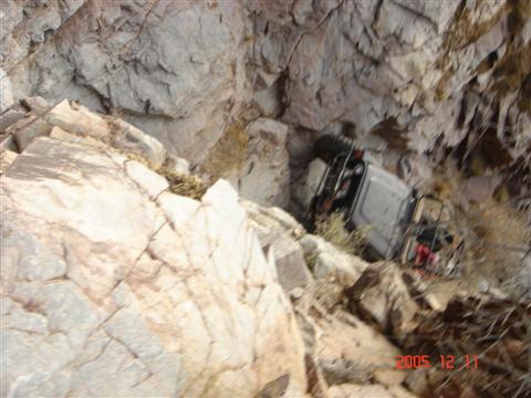 1994 Ford Bronco - A vehicle has crashed down a rocky incline, resting on its side.