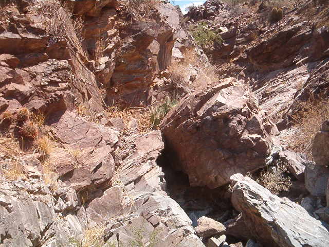 Rocky hillside with desert vegetation and a Supermotors.net watermark