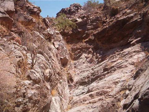 1994 Ford Bronco - A person stands atop a rocky outcrop in a desert canyon landscape.