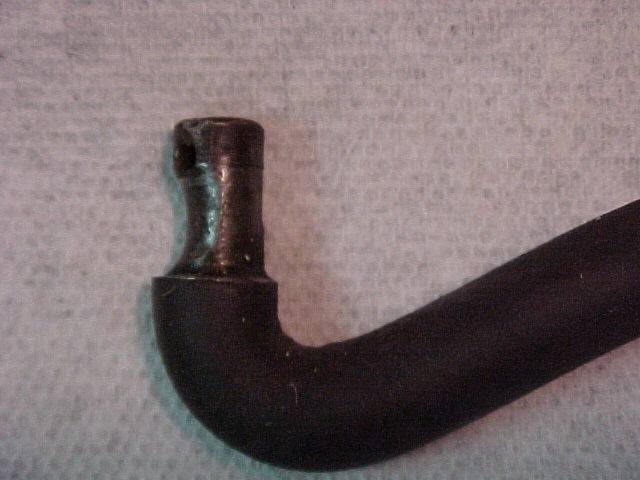 Close-up of the end fitting of a black metal tube on a textured surface