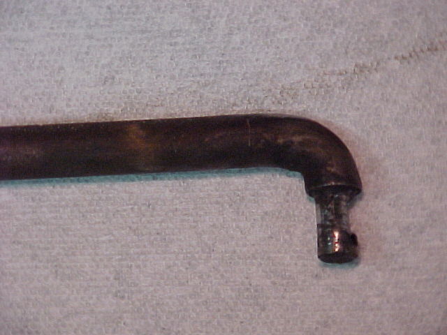 Close-up of the opposite end fitting of a black metal tube on a light surface