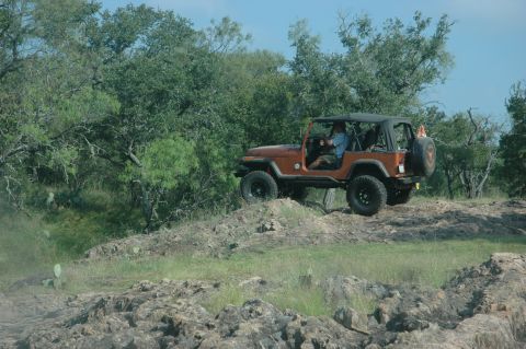 2001 Jeep Wrangler - Jeep CJ-7 navigates a rocky trail, demonstrating off-road capability.