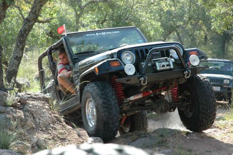 2001 Jeep Wrangler - Black Jeep Wrangler navigates a rocky trail with a second Jeep in the background.