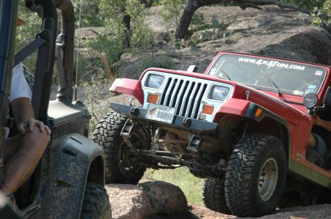 2001 Jeep Wrangler - Two Jeeps off-roading on a rocky trail, one red and one dark colored.
