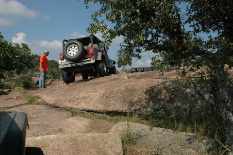 2001 Jeep Wrangler - Several Jeeps navigate a challenging off-road course on a sunny day.