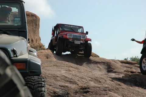 2001 Jeep Wrangler - Two Jeeps navigate a challenging rocky terrain under a clear blue sky.