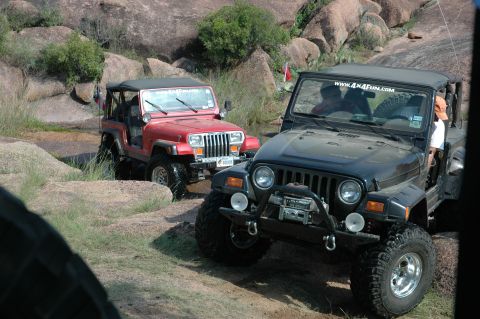 2001 Jeep Wrangler - Two Jeep Wranglers navigate a rocky off-road course, with one vehicle prominently displaying a website sticker.