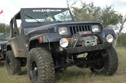 2001 Jeep Wrangler - Dark blue Jeep Wrangler modified for off-road use, parked outdoors with another vehicle nearby.