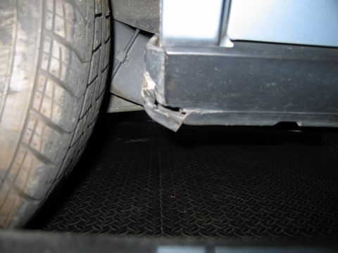 1991 Ford LTD Crown Victoria - The lower trim piece on the vehicle's side is damaged and peeling away from the body.
