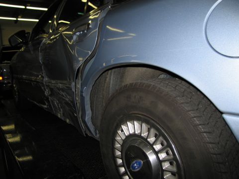 1991 Ford LTD Crown Victoria - The rear passenger side of a blue 1991 Ford Crown Victoria LTD shows extensive damage.
