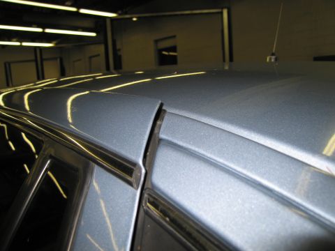 1991 Ford LTD Crown Victoria - Close-up view of the roofline and window trim on a gray vehicle.