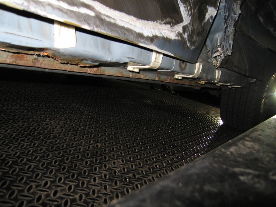 Close-up of a rusted rocker panel on a vehicle, showing damage and repair work