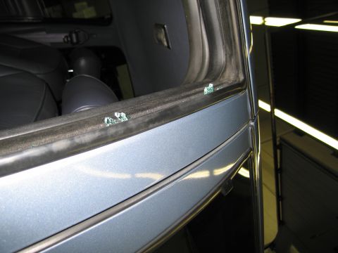 1991 Ford LTD Crown Victoria - Shattered glass fragments are visible on the window frame and door panel of a car interior.