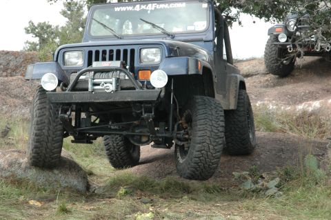 2001 Jeep Wrangler - Two Jeeps navigate a rocky, off-road trail under a tree.