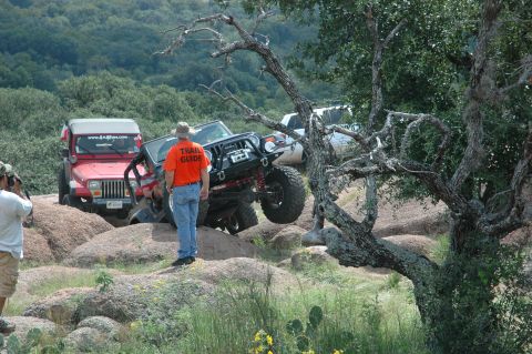 2001 Jeep Wrangler - A group of Jeep Wranglers navigate a challenging rocky trail with a trail guide observing.