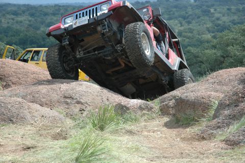 2001 Jeep Wrangler - Red 2001 Jeep Wrangler navigating a rocky trail with another Jeep visible.