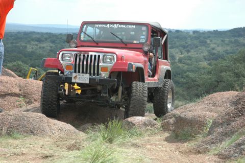 2001 Jeep Wrangler - This red Jeep Wrangler navigates a rocky terrain, its off-road capabilities.