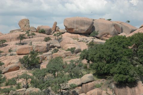 2001 Jeep Wrangler - Rocky landscape with large granite formations and sparse vegetation under a partly cloudy sky.