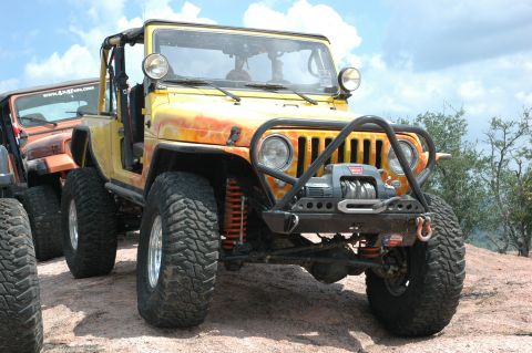 2001 Jeep Wrangler - Two Jeeps are parked on a rocky surface under a cloudy sky.