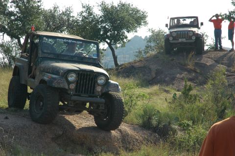 2001 Jeep Wrangler - Two Jeeps navigate a rocky, off-road terrain under a clear sky.