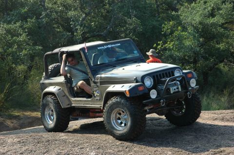 2001 Jeep Wrangler - A 2001 Jeep Wrangler is shown off-road with a driver and passenger enjoying the terrain.
