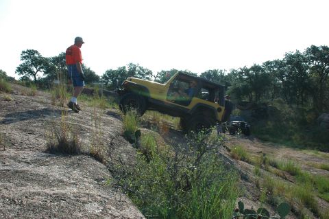 2001 Jeep Wrangler - Two Jeeps navigate a challenging rocky terrain under a clear sky.