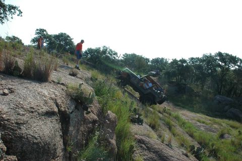 2001 Jeep Wrangler - A 2001 Jeep Wrangler navigates a steep, rocky terrain with onlookers observing the off-road adventure.