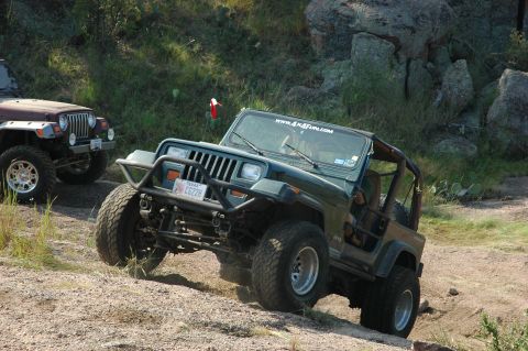 2001 Jeep Wrangler - Two Jeeps navigate a rocky, off-road trail on a sunny day.