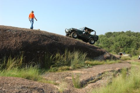 2001 Jeep Wrangler - A Jeep Wrangler navigates a rocky incline while another vehicle is visible in the background.