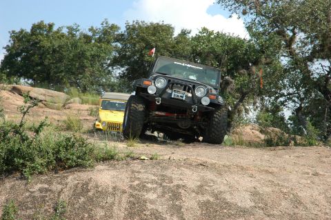 2001 Jeep Wrangler - A black 2001 Jeep Wrangler navigates a rocky trail with a yellow Jeep visible behind it.