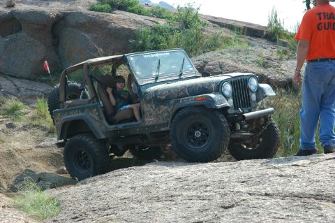 2001 Jeep Wrangler - A Jeep CJ-7 navigates a rocky trail with a trail guide observing.