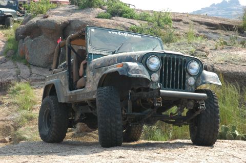 2001 Jeep Wrangler - Green Jeep CJ-7 parked on a rocky trail with another Jeep in the background.