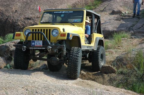 2001 Jeep Wrangler - A yellow 2001 Jeep Wrangler navigates a rocky off-road trail.