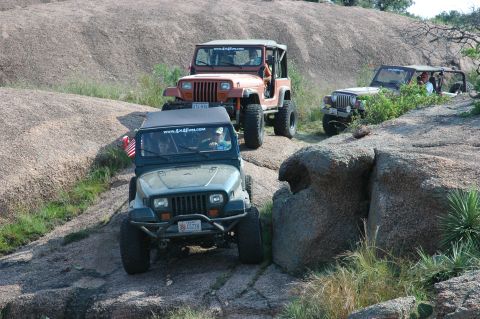 2001 Jeep Wrangler - Several Jeep Wranglers navigate a challenging rocky landscape, their off-road capabilities.