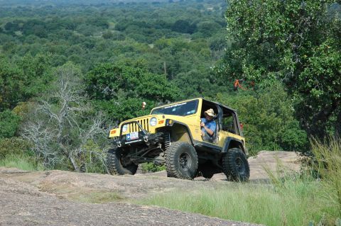 2001 Jeep Wrangler - Yellow 2001 Jeep Wrangler navigates a rocky off-road path.