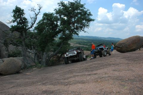 2001 Jeep Wrangler - Off-road vehicles navigate a challenging rocky terrain under a partly cloudy sky.