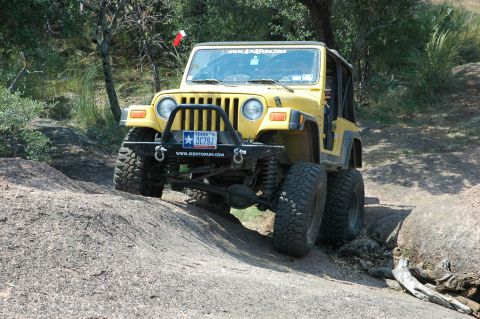 2001 Jeep Wrangler - This yellow Jeep Wrangler is navigating a rocky off-road trail, its capabilities.