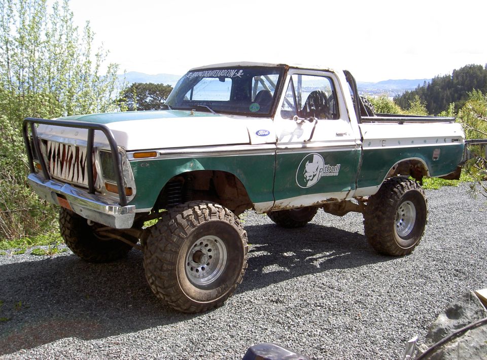 1979 Ford F-150 pickup truck, green and white, with custom grille and lifted suspension