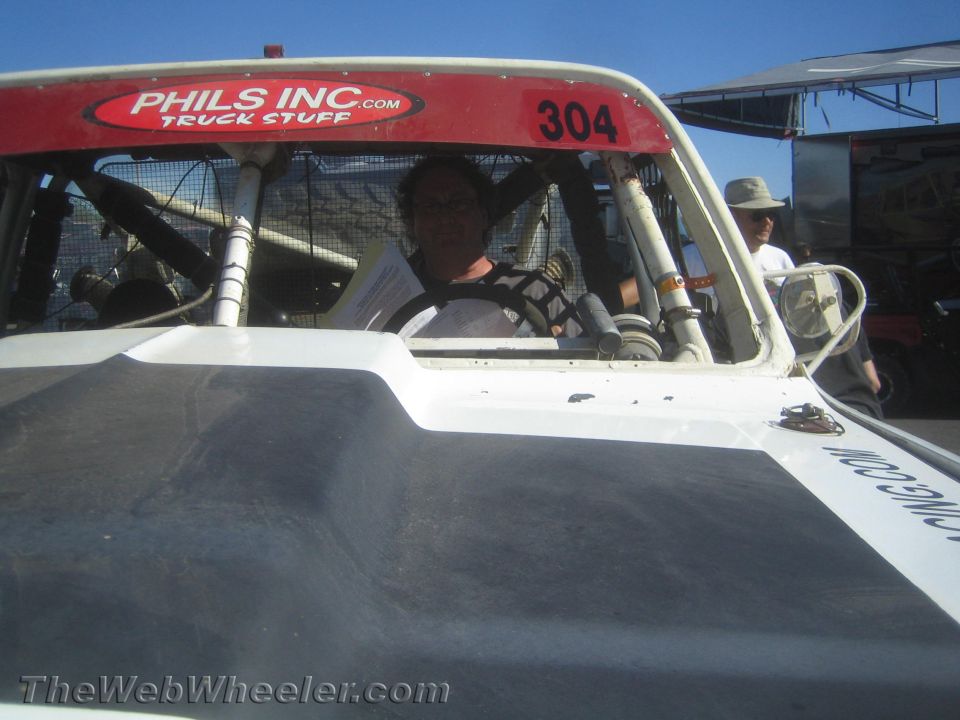 Driver seated in cockpit of off-road race truck #304 behind windshield