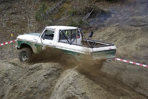 1979 Ford F-150 - This 1979 Ford F-150 navigates a challenging off-road course, kicking up dirt as it climbs.