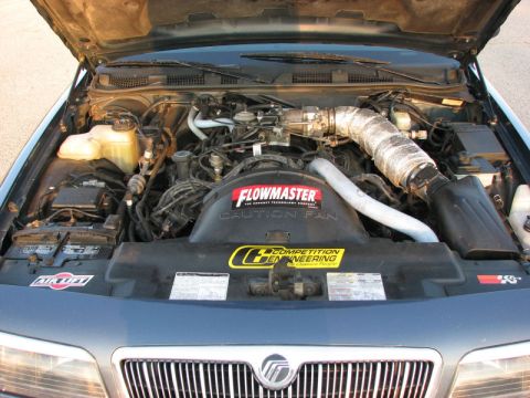 1985 Mercury Grand Marquis - The engine bay of a Mercury Grand Marquis, a Flowmaster fan shroud and custom intake system.
