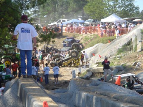 2002 Jeep Wrangler - Competitors navigate a challenging off-road course, with one vehicle overturned during the event.
