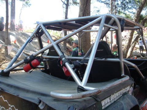 2002 Jeep Wrangler - This heavily modified off-road vehicle features a prominent roll cage and safety equipment, suggesting it is built for extreme terrain.