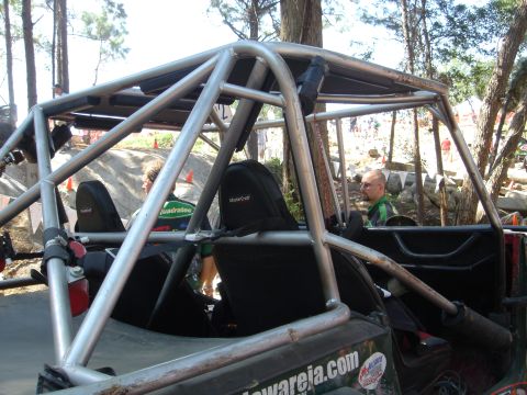 2002 Jeep Wrangler - This off-road vehicle features an extensive roll cage and is seen in an outdoor, wooded environment.