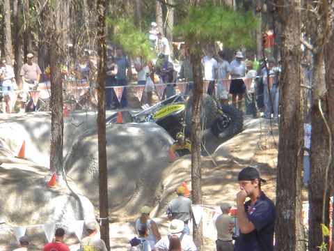 2002 Jeep Wrangler - An off-road buggy navigates a challenging rocky course with spectators observing the event.