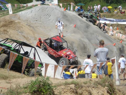 2002 Jeep Wrangler - A red 2002 Jeep Wrangler navigates a steep, rocky obstacle course during a competition.