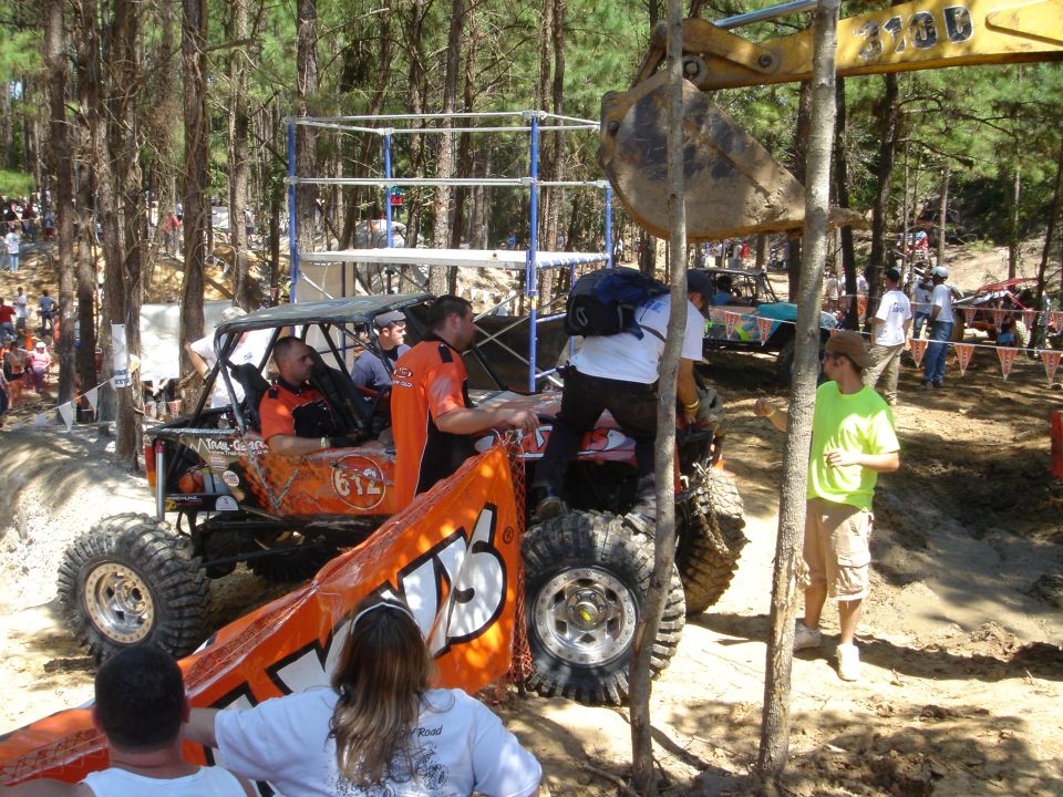 Orange off-road rock buggy #612 with big mud tires at a wooded off-road event